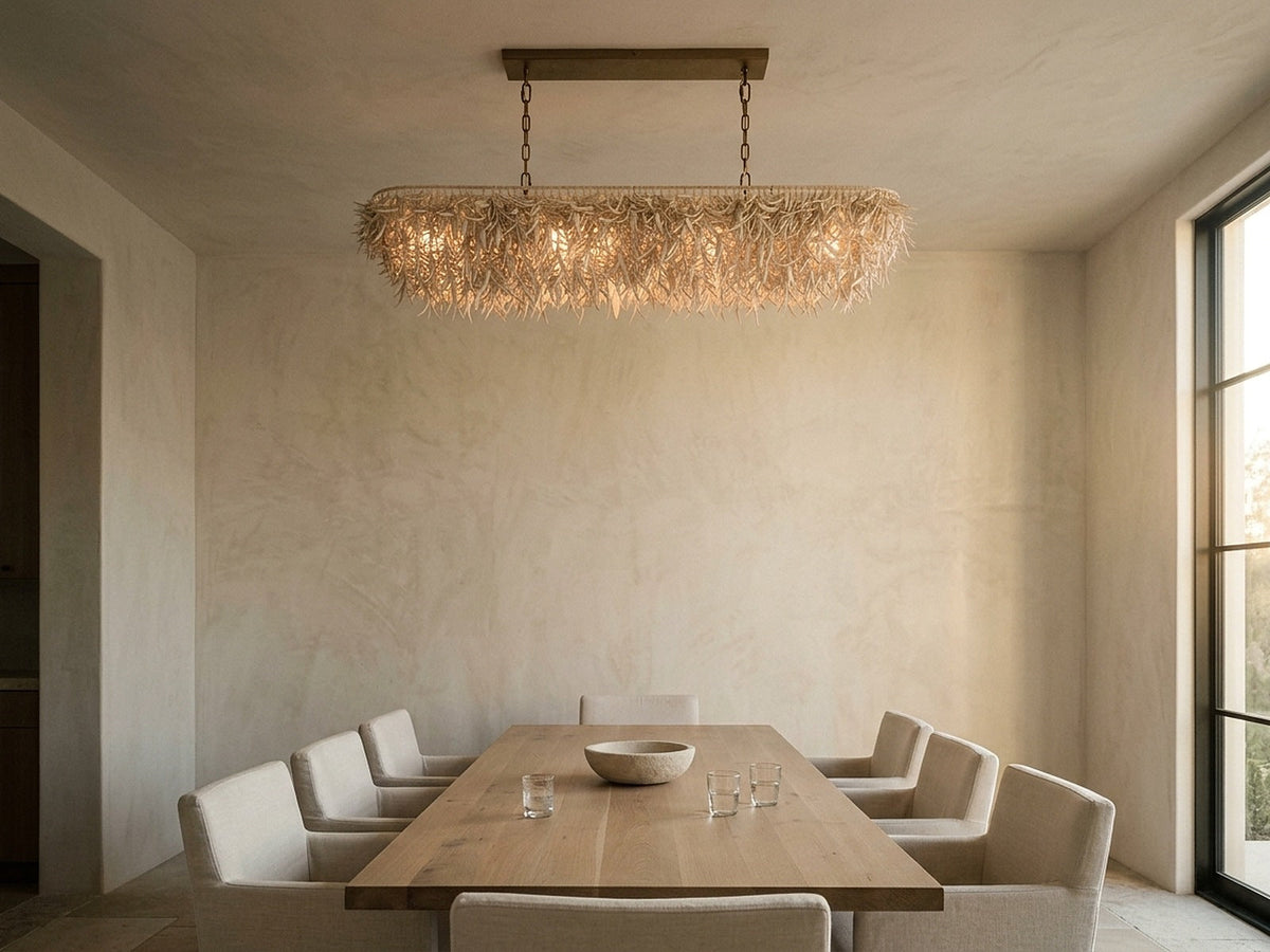 Linear chandelier centred over a long oak dining table in a tall room
