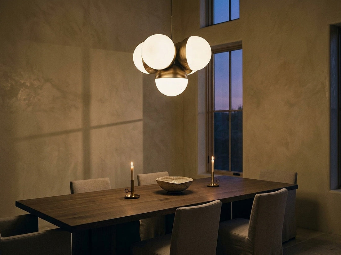 Chandelier hung with generous clearance above a dining table at dusk