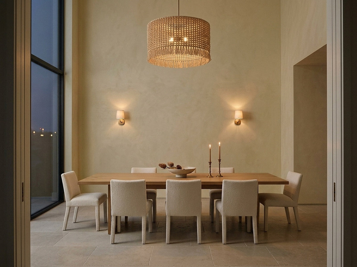 Dining room lit in layers by a chandelier, sconces and candles